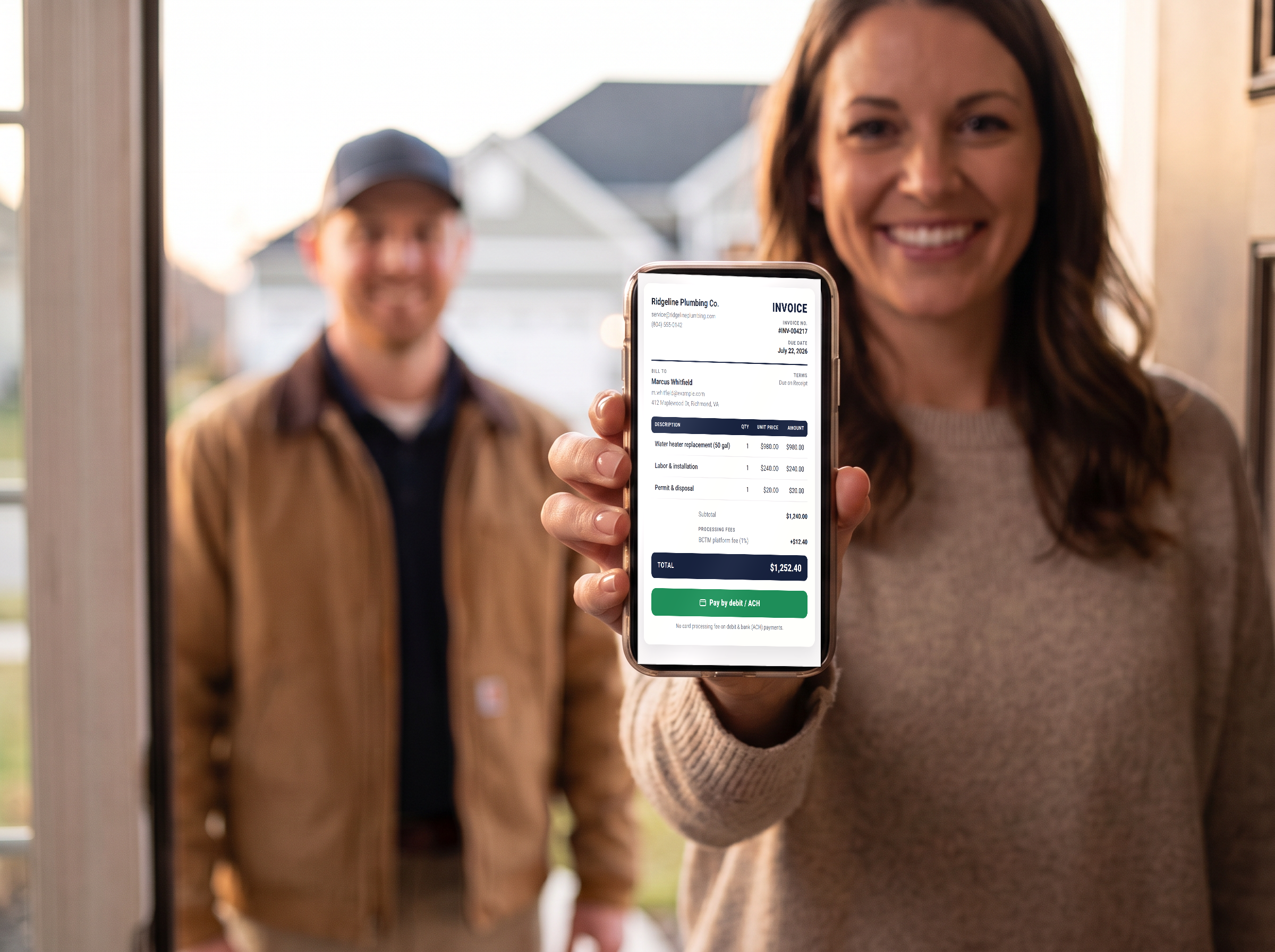 A customer holding her phone showing a Blue Collar Trade Manager public invoice with a Click to Pay button